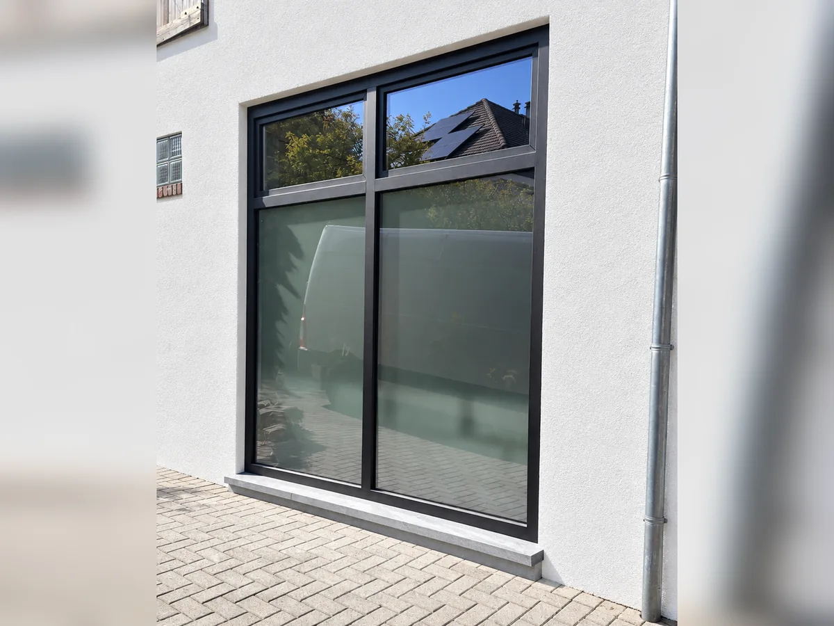 Vue projetée (simulation, pas une photo) : la baie vitrée en aluminium anthracite avec imposte, une fois la façade enduite en blanc et le seuil terminé