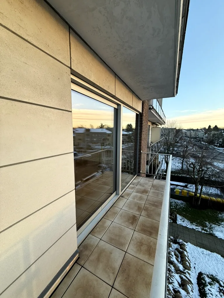 Baie coulissante à profilé sombre sur une terrasse d’appartement en hauteur — réalisation Pulsar Windows