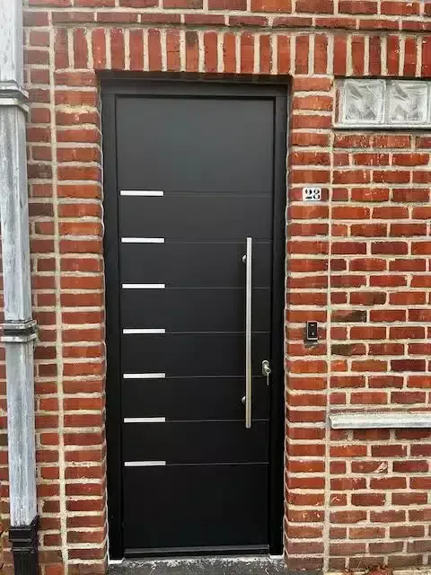 Porte d’entrée anthracite à inserts inox installée à Beersel — Pulsar Windows