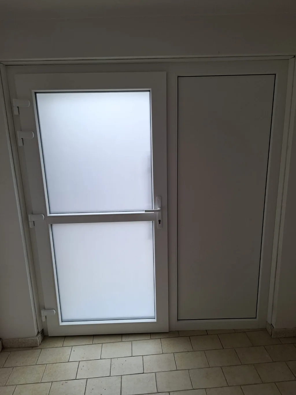 After: the new entrance door seen from inside, white finish (two-tone)