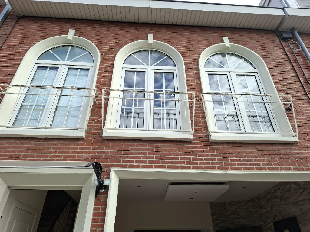 Before: front façade with old arched timber windows