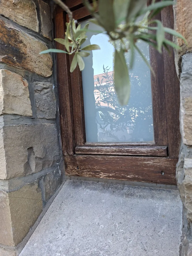 Avant : ancienne fenêtre en bois sur un mur en pierre