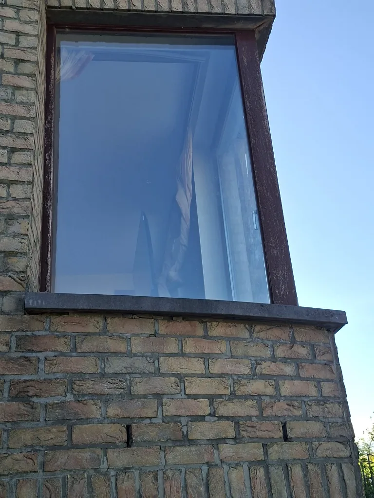 Before: old timber corner window on a brick wall